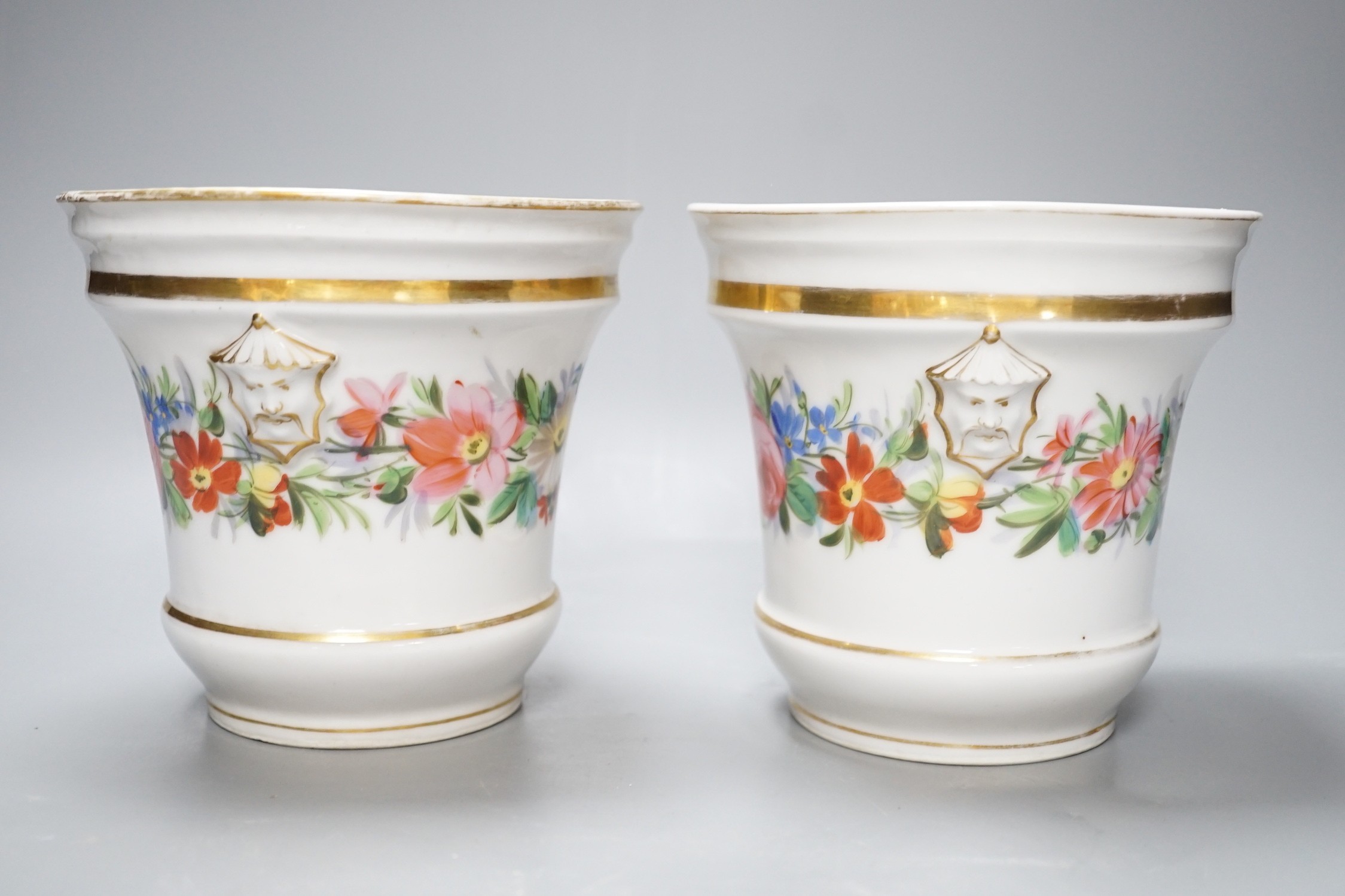 A 19th century pair of Paris porcelain flowers pot with Chinese figural heads, a chain of flowers and four gilt bands and a Continental circular plaque painted with a lady on a brown ground, flower pots 14.5 cms high